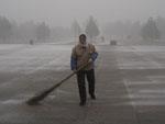 Old lady sweeping snow